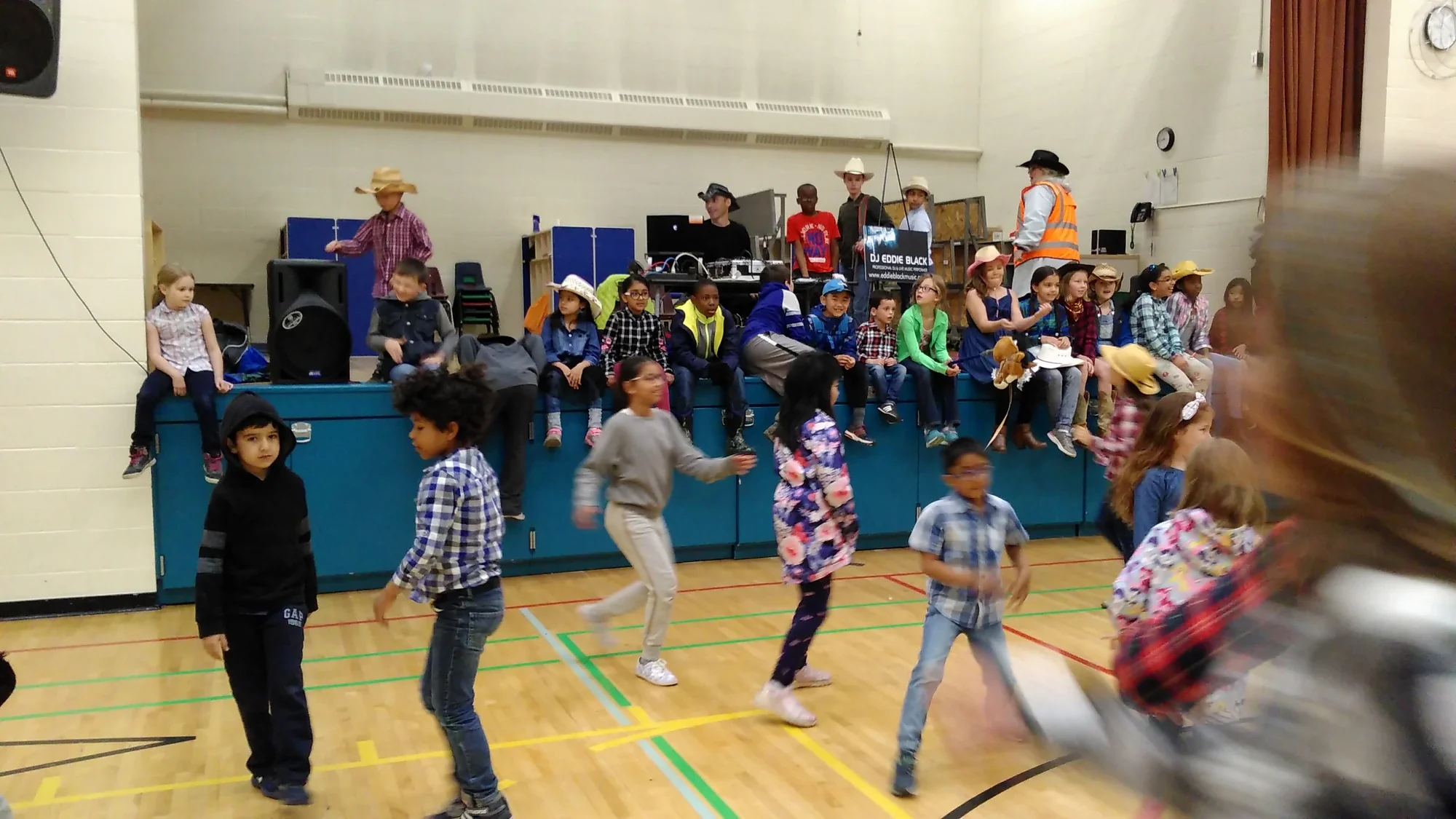 DJ Eddie Black school event — kids dancing at a Calgary Stampede school breakfast with DJ Eddie Black banner