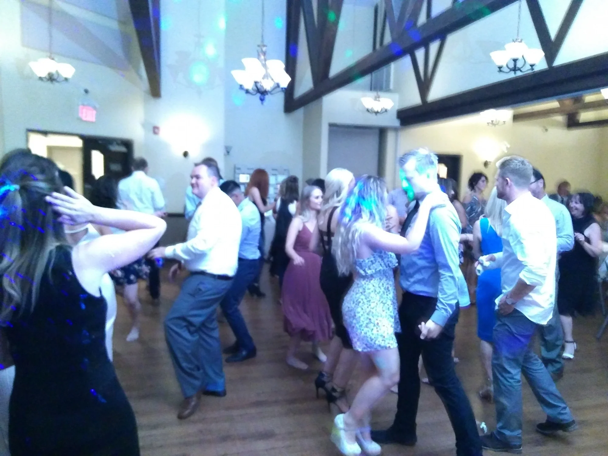 Wedding reception dance floor packed with dancers under blue lighting — Calgary wedding DJ